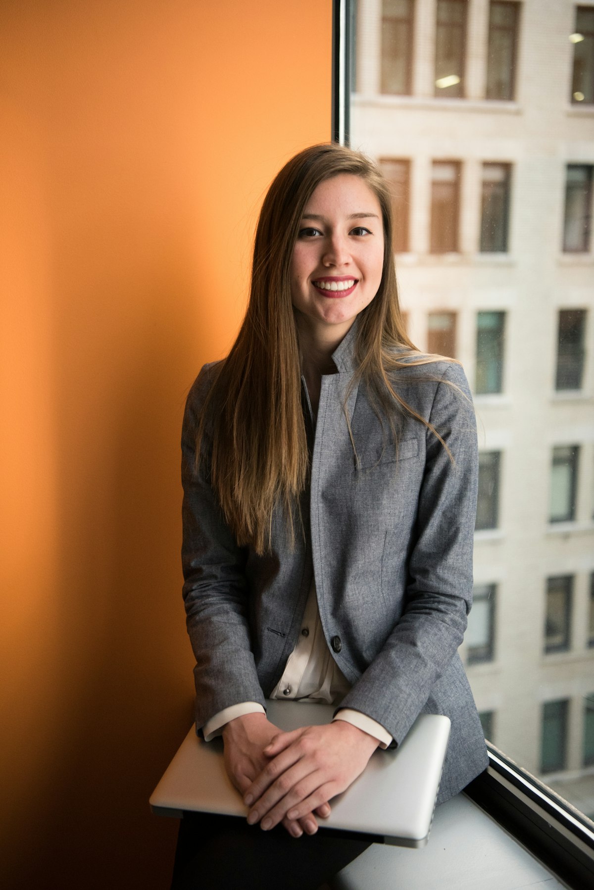 A smiling professional seated by a window